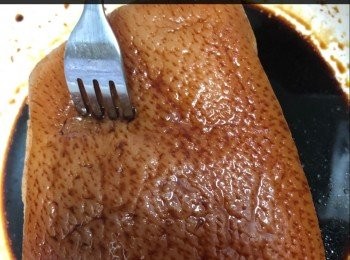 step1: 腩肉慢火煮熟，用叉插豬皮，塗上老抽、酒。