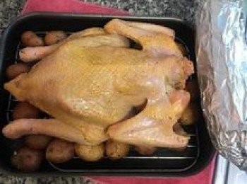 step14: 擺在吹好風的雞週圍和下方，這邊的重點是利用馬鈴薯將雞能撐平高，這樣烤的時候才會均勻；接著就可以入烤箱200度烤30分鐘（烤架放第二格，烤盤放上面）；甜玉米則擺在烤盤的手把位置一起烤；