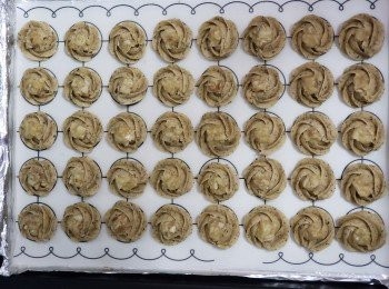 step3: 將雪好左嘅焦糖堅果取出，分割成一小粒狀。再取出唧好花紋嘅曲奇，將將一小粒嘅焦糖堅果放在曲奇面。放入已預熱焗爐，已180'c焗28分鐘即可。