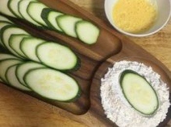 step4: 平底鍋放少許的油，小火加熱；接著將蛋打散；取櫛瓜先兩面沾粉後，再沾上蛋液；