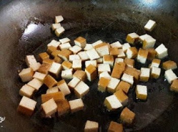 step2: 鍋子中加入1湯匙油燒熱後 , 加入豆干粒炒至金黃