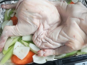 step5: 如果有大器皿，可以用更多蔬菜和上湯浸豬。蔬菜墊底加上香料和上湯，蔬菜面鋪上乳豬。