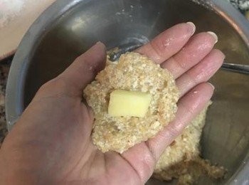 step9: 準備一個盤子，放上太白粉；將手沾濕，舀一湯匙的雞肉豆腐放手心壓扁後，擺上一顆馬薩瑞拉起司後包成圓球狀，