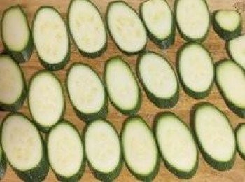 step2: 櫛瓜去頭尾後斜切成約0.5公分厚片；撲平在枮板上；均勻撒上鹽後靜置3-5分鐘讓櫛瓜出水；