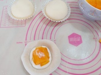 step7: 取一塊皮，加入淡忌廉、芒果和柚子醬，包起整圓。