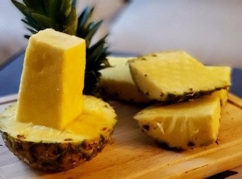 step2: 先把菠蘿切去頂部， 把菠蘿留下菠蘿芯位置及底 樁，切去四邊之菠蘿肉備用 ( 切勿把中心位置切得過幼， 預留粗壯一些的菠蘿芯， 以填滿雞內籠的空間 ) ，另外把菠蘿肉起出， 用白酒炒香作為伴碟 ( 白酒可令菠蘿肉更鮮甜 )