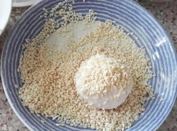 step4: 在煎堆表面沾少許水，再沾滿白芝麻