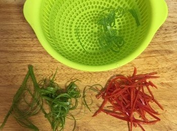 step15: 蒸梅干扣肉時，利用時間，先用冷開水洗淨蔥和辣椒，辣椒去籽切細絲；蔥去蔥白後切細絲，然後與辣椒絲一起泡在冷開水中；