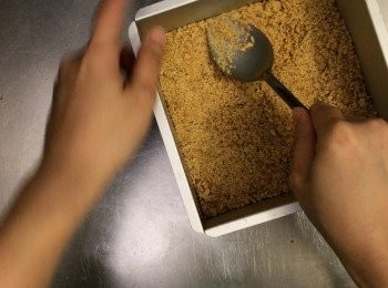 step4: 蛋糕模底先墊上一塊烘焙紙
將消化餅碎倒下去，用大匙抹平
之後入雪櫃雪最少30分鐘備用