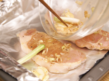 step3: 將豬扒平鋪在烤盤上，在豬扒上面放<span class="group_2">醃料</span>，然後放入已預熱190度的焗爐，焗15分鐘，之後將豬扒翻轉再焗15分鐘，取出。 