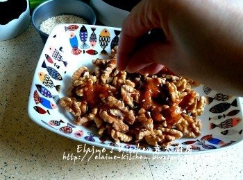 step8: 核桃肉放上碟或碗內 , 糖漿趁熱倒入核桃肉內 , 再灑上白芝麻拌勻