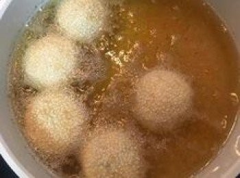 step21: 炸到開始略微浮起時，就可用濾網或湯匙開始壓放芝麻球，重覆幾次後，芝麻球漲大到原來的一倍大，就用湯匙不停攪動芝麻球，讓其滾動幫助受熱均勻，待芝麻球呈金黃色時即可起鍋瀝油；