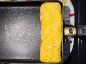 step16: 卷好後在底部壓一下成型，熄火放冷。
＊壓一下玉子燒才能呈現美美的四角形喔～