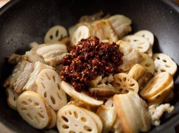 step3: 再來放入老干媽香辣脆油辣椒、米酒、醬油與鹽巴炒到入味。