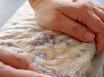 step7: 盡量把料放在牛油紙一邊，摺上另一邊後盡量壓平均, 用手把其餘三邊旁齊