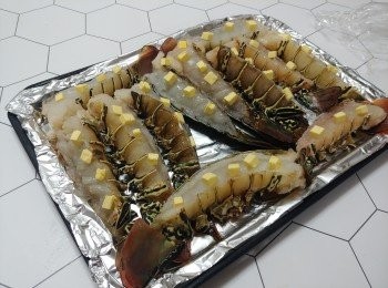 step3: 將<a href="https://bit.ly/3CaaqmB" target="_blank" data-keyword="龍蝦尾" class="guide-link"><strong>龍蝦尾</strong></a> <span style="display:inline-block;vertical-align:middle;margin-top:-3px;color:initial;border-radius:3px;padding:2px 3px;font-size:12px;line-height:14px;background:#87d300;color:#fff;">即買</span> 放在舖上錫紙的烤盤上， 在每邊蝦上放上3粒牛油粒