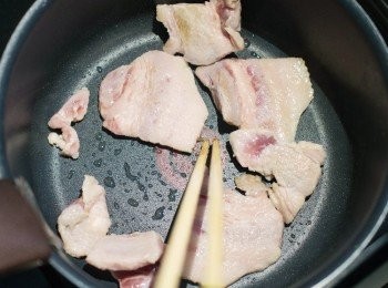 step3: 在鍋子內倒入麻油，加入豬肉炒，中途灑點胡椒鹽，豬肉會呈現漂亮的金黃色