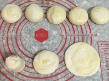 step20: 接著取一捲直立，先將一端捏緊後，再反過另一端，用手壓扁，然後用橄麵棍橄成中間較厚的圓片狀；