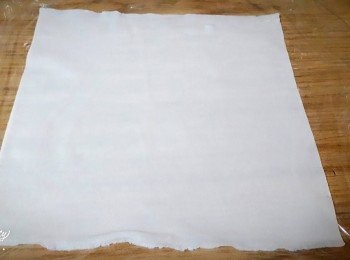 step2: 在桌上先舖一張保鮮膜 , 把春卷皮放在上面 , 雞蛋打散再把春卷皮刷一下 , 整張刷滿