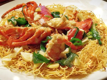 step4: 用油起鑊爆香薑、蒜頭， 加入龍蝦炒至半熟， 加入雞湯煮滾， 再加入蔥段炒勻， 最後以生粉水埋芡， 淋在兩面黃上，即成