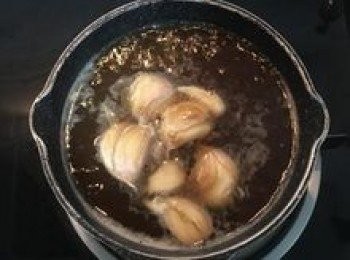step19: 小湯鍋放入拍扁帶皮的蒜頭、水和醬油膏煮滾；並用鹽和糖調味；