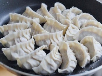 step6: 燒熱鑊後下油，然後下餃子，整齊排好，加100毫升水，蓋上鑊蓋，用中火煮三分鐘