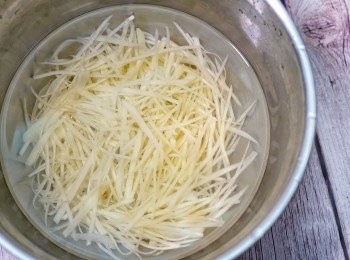 step4: 馬鈴薯去皮潔淨，切成細絲。
📝薯仔要用普通的馬鈴薯，用焗薯的話就不夠爽口，容易斷掉。
薯絲放入水裡沖洗幾次，去除多餘的澱粉。