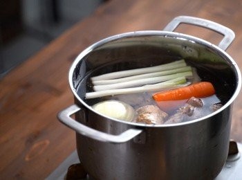 step2: 接下來準備一個乾淨的鍋子，將雞骨頭、冷水以及其他<span class="group_1">食材</span>全部下鍋，大火煮滾。