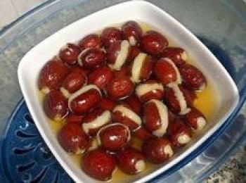 step13: 剛蒸好時糯米糰會有些膨脹，先不要動，待略降溫後即會與紅棗更貼合；取出蒸好的糯米紅棗擺盤；並將桂花蜜混入糖水中拌勻；