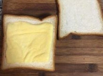 step9: 將抹好<span class="group_2">甜奶油</span>的那面蓋在起司上後，於吐司背面再抹上美奶滋，並放了蛋皮；取另一片吐司抹上美奶滋後蓋在蛋皮上，一份古早味三明治便完成了。