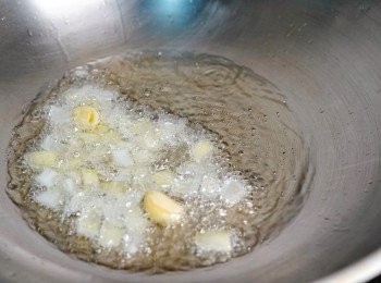 step2: 葵花籽油用小火煮滾，放入洋蔥及蒜頭粒炸香，然後撈出關火。