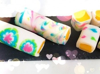 step4: 係面皮上加入熟粉...反轉...撕去焗爐紙....放上芒果條..捲上..之後掃走多餘粉粒.....就可以