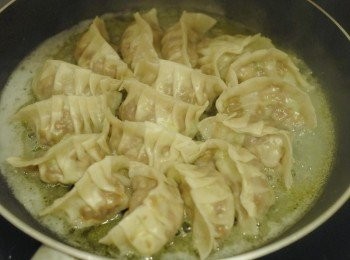 step7: 打開鑊蓋，一半的水會蒸發，下香油，然後繼續煎餃子至水份全乾，餃子底部煎至金黃色即成！