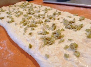 step4: 取出按偏排氣，用麵粉棍壓成長方塊狀，加入芝士粉及橄欖碎