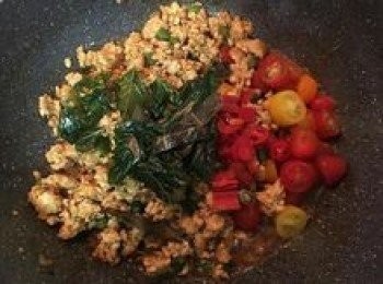 step10: 炒到雞肉上色後請試調味做調整，接著放入煸炒過的九層塔與檸檬葉，再加入小蕃茄繼續拌炒；