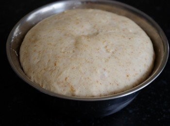 step3: 滾圓麵團，在大碗旁及麵團表面塗上薄薄的油，以防蓋上保鮮紙後粘著 
 焗爐預熱170度1分鐘，然後關上焗爐電掣，放整盤麵團入爐發酵1小時, 發酵1小時後會膨脹至2倍大如圖