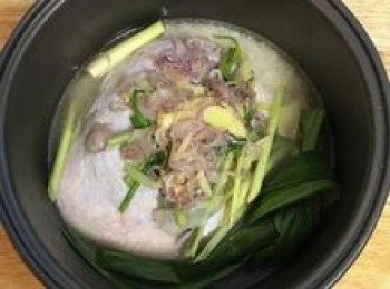 step9: 擺入雞腿，並把醃雞腿的蔥、薑、香茅段也放在雞肉上，接著把濾出來的爆香料也擺進飯鍋中，再放入斑蘭葉；接著將內鍋放入煮飯鍋，按一般煮飯行程，飯煮好後請不要開蓋，多燜15～20分鐘。