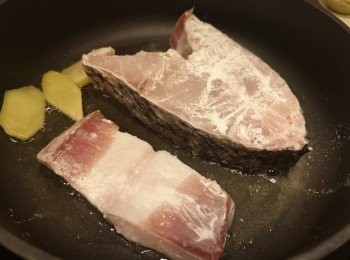 step2: 魚洗乾淨索乾水份，表面撲上粟粉，用薑片起鑊，慢火煎封魚表面。