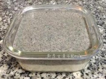 step11: 取出冰鎮的<span class="group_2">椰奶雪花糕</span>，除去保鮮膜（保鮮膜如不沾黏即表示表面已凝固），倒入<span class="group_3">芝麻雪花糕</span>醬，表面抹平後震出空氣，入冰箱冷藏1小時以上，直至雪花糕成型。