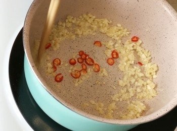 step5: 於鍋內倒點油，小火爆香蒜蓉及指天椒。