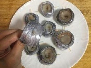 step3: 用半匙鹽和一茶匙米酒均勻抹在白帶魚卷上，接著找到白帶魚卷的尾端用牙籤插串固定。