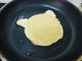 step3: 煎完1分鐘後，就將喵咪圓形面上沒有粉漿的位置填滿，
中火再煎太約1分鐘，直至見到起氣孔