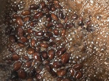 step3: 待煲裡的水再次大滾後，轉小火，上蓋續煮約1.5至2小時（期間觀察水位，若水份減少至黑豆暴露於空氣中，可加200毫升熱水蓋過豆面，繼續焗煮），然後試一試豆的軟硬度。