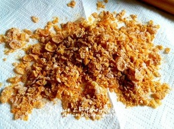 step3: 期間將香甜粟米片放在廚紙上 , 再蓋上另一張廚紙 , 用麵棍來回壓碎粟米片