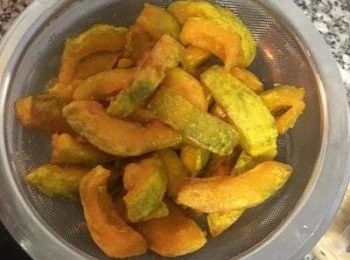 step7: 即可將整鍋連同南瓜倒到放了濾網的鍋裡，濾掉油。