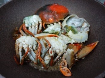 step10: 洗乾淨隻鑊再準備炒蟹，
大火落少少油+薑片，放蟹件落去煎大約5分鐘，
再炒一炒加酒煮5分鐘，