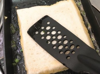 step7: 隨即用鑊鏟輕壓麵包，令蔥花黏附在麵包上，煎至金黃色，再反轉煎另一面。