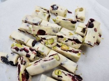 step3: 將開心果仁和紅莓乾倒入，混合均勻
、倒入牛油紙上，將牛油紙對折，再用碌麵棍碌平均、
待凉先平均分成27份