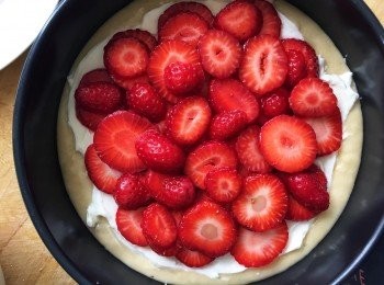 step5: 在另一碗內，將忌廉芝士攪拌至幻滑。加入剩餘的1茶匙雲呢拿油和50克砂糖，拌勻。塗在<span class="group_2">蛋糕</span>糊上，上面鋪上草莓（如圖）。