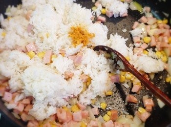 step4: 加入香腸粒、粟米粒炒勻，再加入冷飯和黃薑粉炒至勻和。